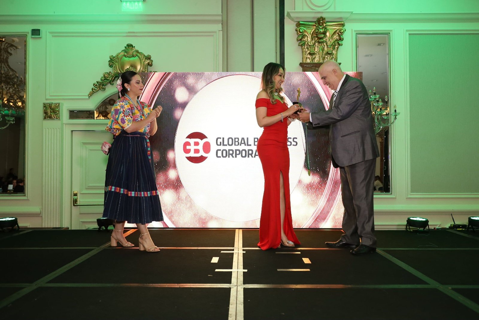 Entrega de un galardón ante la pantalla de Global Business Corporation